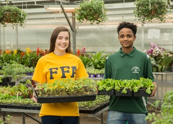 Two students holding seedlings. 