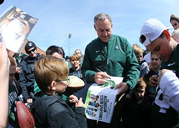 Coach Dantonio signs autographs for young fans