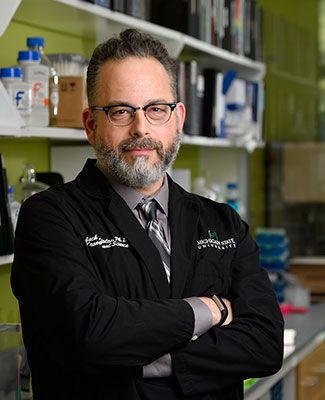 Jack Lipton stands in his lab wearing a black labcoat