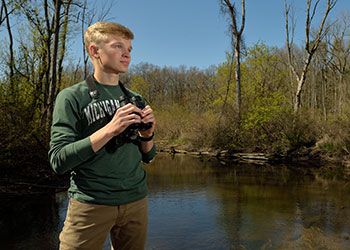 Evan Griffis observes birds as part of his research project