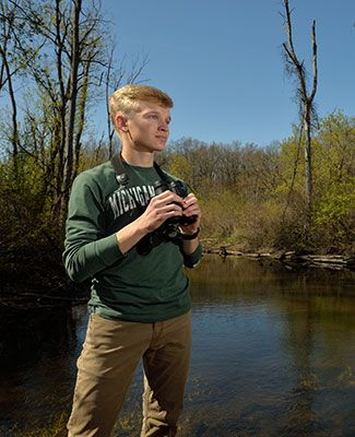 Evan Griffis observes birds as part of his research project