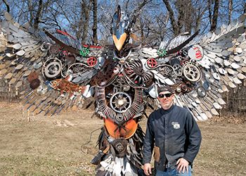 Joe Butts, '98 (Arts and Letters), and his Phoenix sculpture.