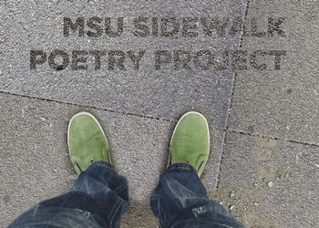 person with green shoes looking down at sidewalk poetry decal.