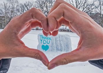 The Rock at MSU painted with survivor names surrounded with hands shaped into an heart