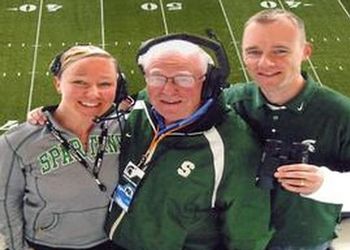 Terry Braverman (center) in the Spartan Stadium public address booth with his assistants for the day, daughter Lindsey and son Christopher.