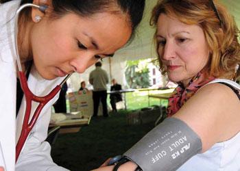 Scholarship recipient Zyra Cortez checks the blood pressure of Germaine Kowatch.