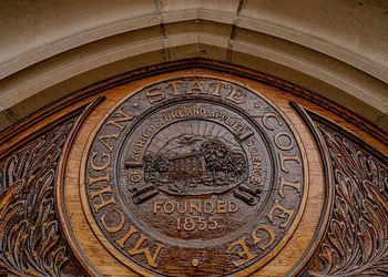 University seal engraved in wood. 