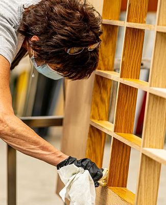 IPF Craftsperson applies varnish to auditorium door. 