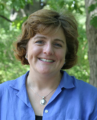 Dr. Margo Glew's professional headshot, taken beneath the trees on campus.