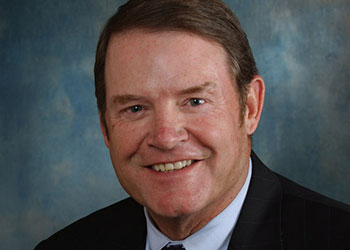 Mike Morris's professional headshot, in a suit, blue shirt, and patterned tie.
