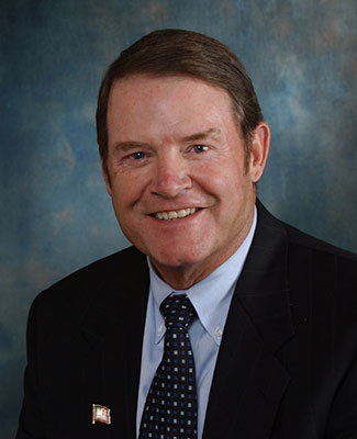 Mike Morris's professional headshot, in a suit, blue shirt, and patterned tie.