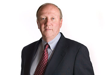 A head and shoulders shot of Bob Burgess, in a dark gray suit and red patterned tie.
