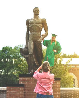 Graduate taking a photo with Sparty