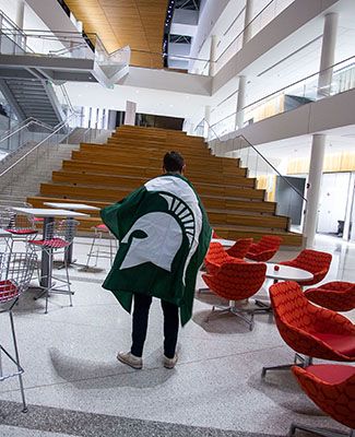 Michigan State University student with Spartan flag.