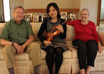 Photo of MSU student violinist Sin Young Kim with donors Ron and Helen Priest