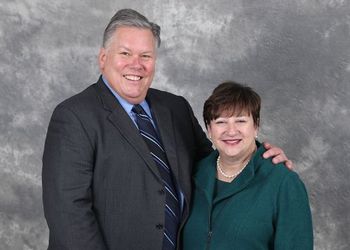 Jim and Sherry Bradow pose against a gray background