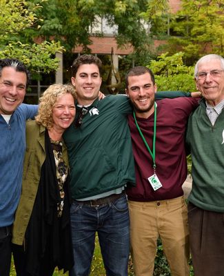 The Riguardi family, dressed for a football game, pose together on campus