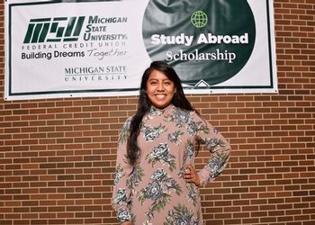 Selena Huapilla-Perez with the MSUFCU Study Abroad banner
