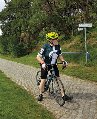 Alumnus George Melnik rides his bicycle