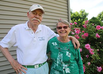 Bill and Sandy Mason pose in front of their prized rosebushes