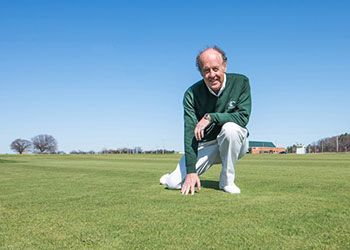 Joe Vargas kneeling on one of the Turfgrass Research plots