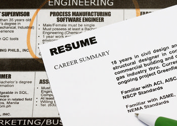 A resume sits on top off a newspaper revealing local job openings