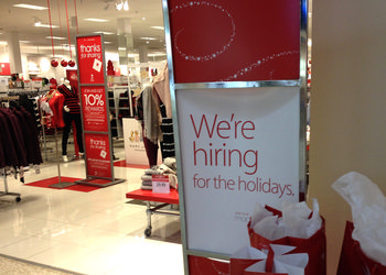 A Macy's holiday display sits in the store with a sign that says they're hiring