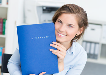 Professional woman holding blue portfolio with a smile