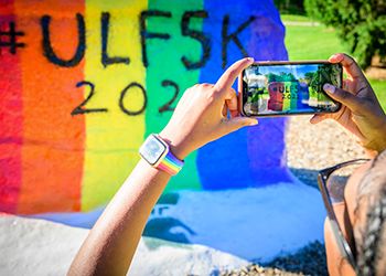 Student snapping a pic of The Rock at MSU ULF5K