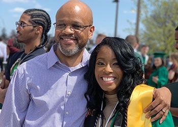 A successful graduate poses with her father