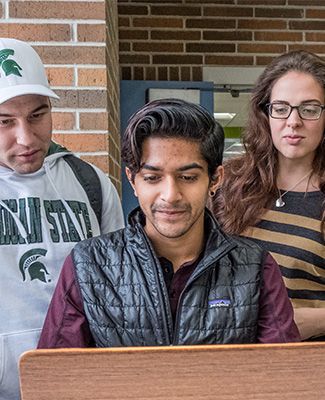 MSU students studying in front of a computer.