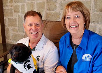 Gary and Erin LaMonte with a labrador retriever puppy named Sparty
