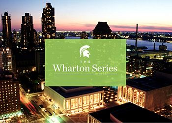 The Lincoln Center at night with the New York City skyline in the background. A light green box overlay features a white Spartan helmet and the text: The Wharton Series.