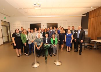 Students and faculty pose at the ribbon cutting ceremony for the new classroom space