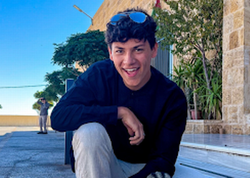 Tyler sitting outside a building