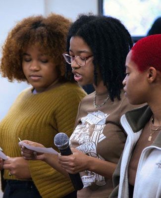 a student speaks into a microphone at the launch of the Department of African and African American studies