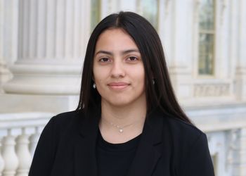 Olivia Heath in a black blazer standing outside the State Capitol.