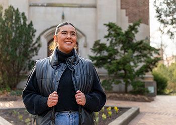 MSU student Valentina Carrasco stands smiling in front of Beaumont Tower.