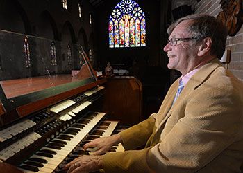 Stephen Lange playing the organ with a big happy smile on his face.