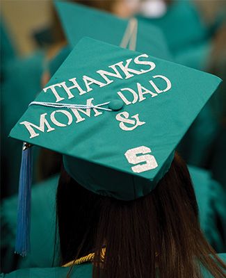 A student wearing an MSU graduation cap that reads, 