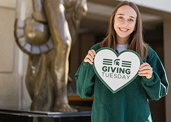 MSU student with Giving Tuesday sign