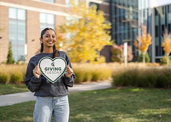 MSU student with Giving Tuesday sign