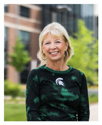 Donnie Haye posing outside on campus in a Spartan shirt