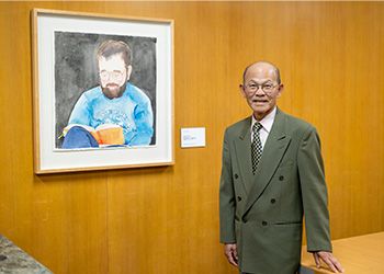 Keelung Hong stands next to a watercolor portrait of Stephen O. Murray.