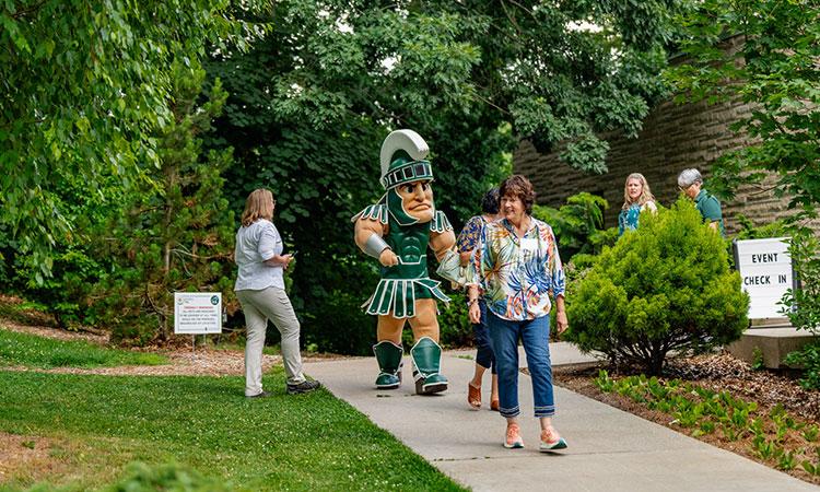 Sparty joins a group of people for a walk.