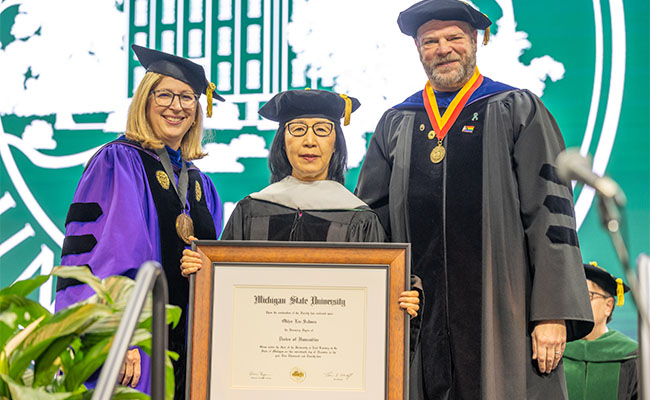 Lee (center) receiving honorary doctorate, pictured with Interim President Teresa K. Woodruff, Ph.D. (left), Interim Provost Thomas D. Jeitschko (right).