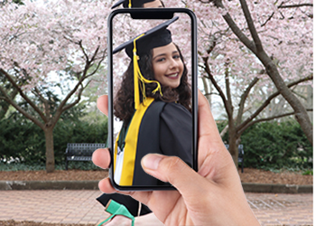 Taking a picture with a phone of a woman in cap and gown